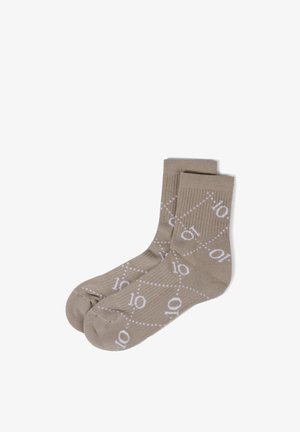 Hellbraune Knöchelsocken mit weißen gepunkteten diagonalen Linien und wiederholtem "10" Muster, nebeneinander flach auf weißem Hintergrund gelegt.