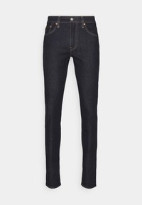 Jeans skinny em denim escuro com detalhes em cobre, cinco bolsos, costuras em destaque e um design de cintura clássica.