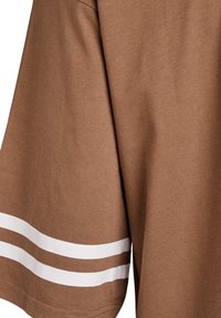 Rjava bombažna majica s kratkimi rokavi, obrobljenimi z belimi črtami blizu roba. Gladek tekstura, preprost dizajn brez dodatnih vzorcev ali grafik.