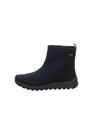 Black ankle boots with a smooth fabric upper, rounded toe, and a flexible rubber sole featuring a wavy texture and a side zipper.