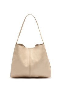 Beige nahkakäsi, jossa on pehmeä texture, epämuodollinen muoto ja yksi olkahihna. Keskellä on sauma yksityiskohta.