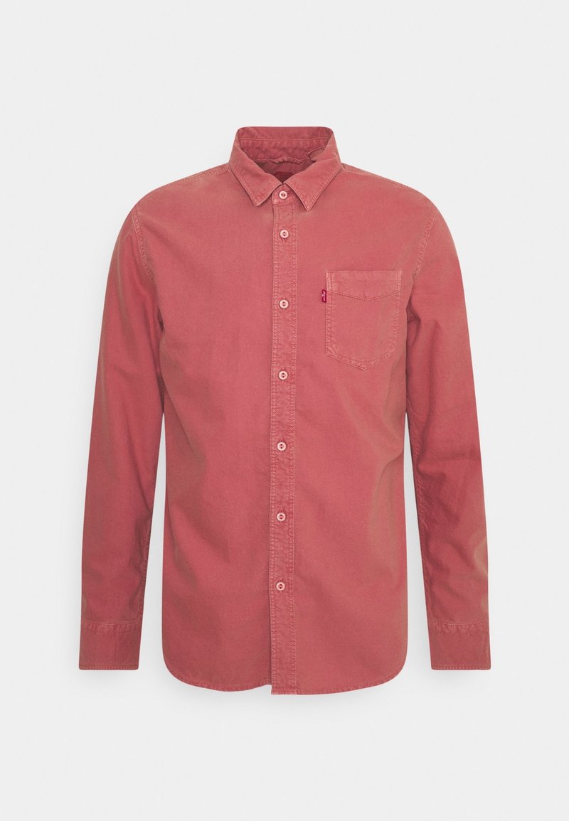 Chemise à manches longues en coton rouge délavé, avec un col à boutons, une poche à l'avant et un logo discret sur la poitrine.