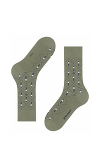 Olivgrüne Socken mit einem Rauten-Muster, das weiße Figuren und marineblaue Akzente zeigt. Der Stoff ist weich und hat eine glatte Textur.