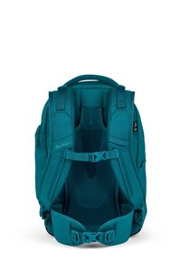 Mochila teal con soporte lumbar de malla ergonómico, tirantes ajustables y bolsillos laterales. Presenta un cierre frontal y un diseño acolchado para mayor comodidad.