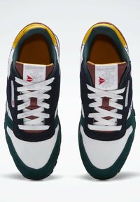 Reebok Classic-sneakers med en blanding av hvit, marineblå, grønn og brun materiale, med et teksturert design og hvite snørebånd.