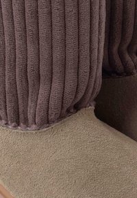 Stivali alla caviglia chunky con parte superiore in tessuto marrone a coste e parte inferiore in morbido suede beige, caratterizzati da una superficie testurizzata e una punta arrotondata.