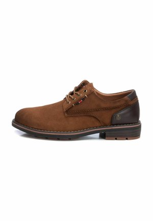 Zapato de ante marrón con un acabado suave, punta redonda, acentos de cuero marrón, diseño de cordones y suela de goma texturizada.