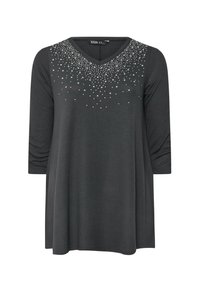 Grijze langslavige top met een V-hals, versierd met decoratieve rhinestones in een gradiëntpatroon over het borstgebied. Zachte stof, ontspannen pasvorm.