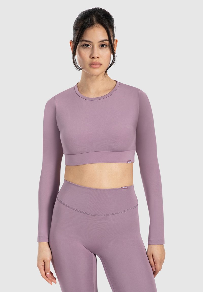 Lavendel een lange mouw crop top gemaakt van een gladde, rekbare stof, met een ronde halslijn en een getailleerd ontwerp, gecombineerd met hoge taille leggings.