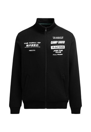 Schwarze Jacke mit Reißverschluss und weißem, rennsportbezogenem Text: "Der Nervenkitzel der Geschwindigkeit", "Camp David Racing" und "Tritt dem Club voller Power bei."