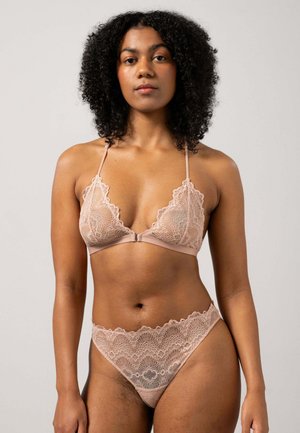 Lace bralette and matching thong in soft nude color. Bralette features scalloped edges and adjustable straps; thong has a lacy waistband.