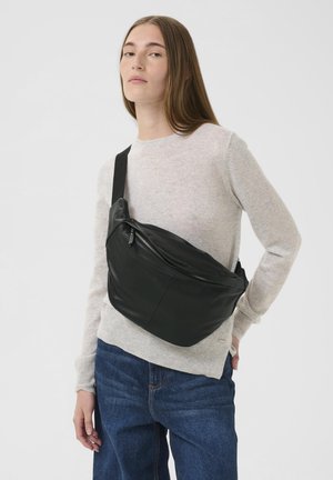 Sort læder crossbody taske med et buet design, der har en lynlåslomme og justerbar rem. Glat tekstur og minimalistisk stil.