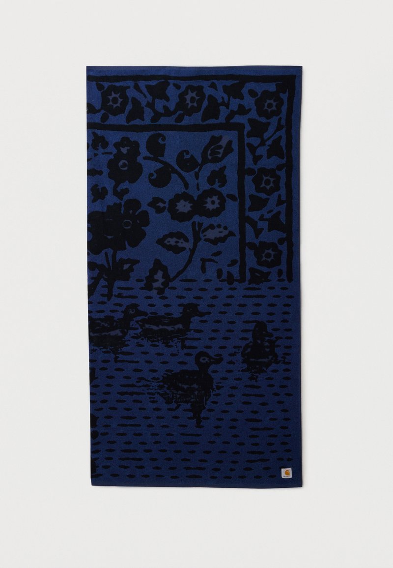 Mørkeblåt stof med sorte blomsterprint og illustrationer af ænder, med et lille Carhartt-logo i nederste højre hjørne.