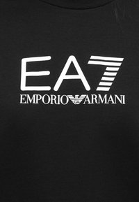 Μαύρο βαμβακερό μπλουζάκι με λευκό λογότυπο που αναγράφει "EA7" πάνω από το "EMPORIO ARMANI", με διακριτικά ριγέ και μονόχρωμα γραφικά στοιχεία.