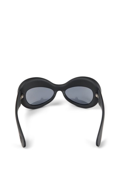 Black sunglasses with a rounded, wraparound design. Features tinted lenses, matte finish, and textured arms with subtle silver hardware.