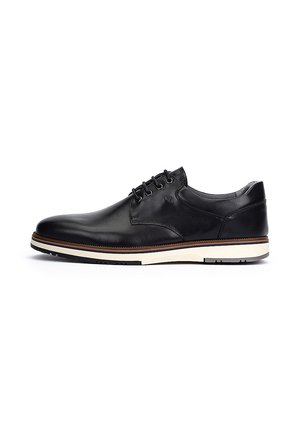 Zapatos de cuero negro con cordones, punta redondeada, suela blanca en contraste, textura suave y sutilezas en las costuras a lo largo del empeine.
