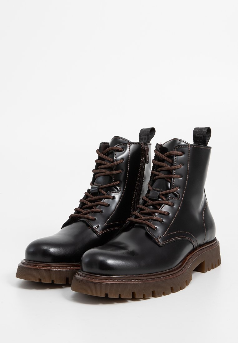 Schwarze Leder-Ankle Boots mit braunen Schnürsenkeln, verstärkter Zehenpartie, strukturiierter brauner Sohle und seitlichem Reißverschluss für einen einfachen Zugang. Flacher Absatz.