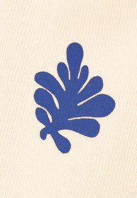 Blaues abstraktes Blattform-Motiv auf einem cremefarbenen, strukturierten Stoffhintergrund.