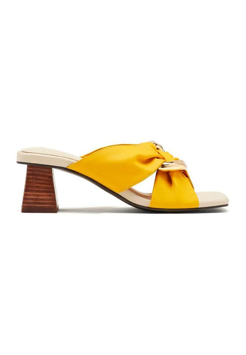 Sandale jaune avec design noué, dotée d'un talon en bois. Matériau lisse avec une semelle intérieure beige contrastante.