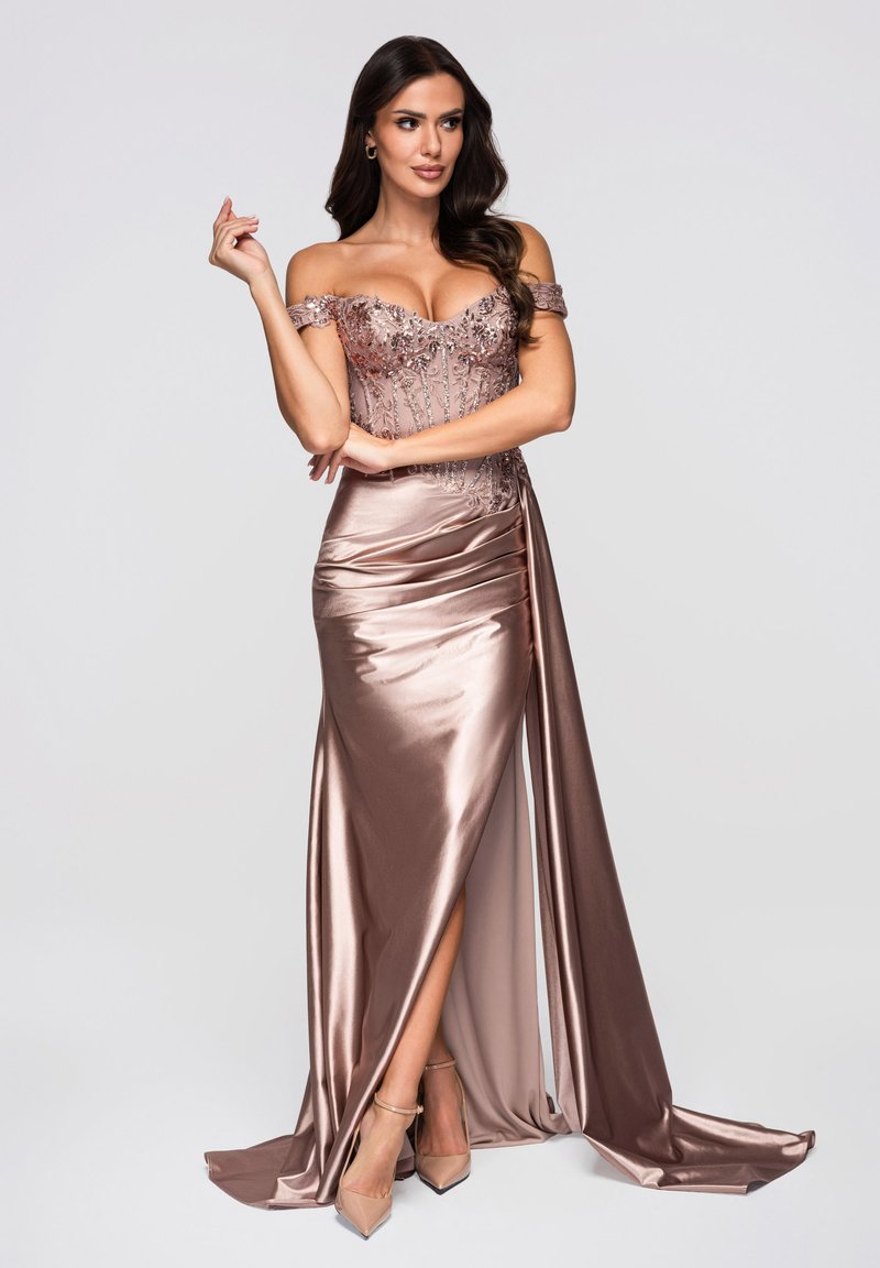 Robe de soirée glamour épaules dénudées en satin rose poudré avec des perles délicates sur le corsage, une fente haute à la cuisse, et une traîne fluide.