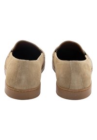 Scarpe slip-on in suede beige con punta arrotondata, suola in gomma nocciola e dettagli cuciti sulla parte superiore. Fodera interna liscia.