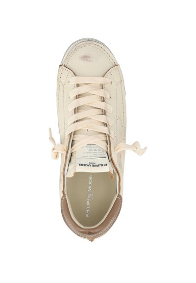 Sneaker in pelle avorio con lacci beige annodati a fiocco, tallone marrone e "PHILIPPE MODEL PARIS" stampato all'interno.