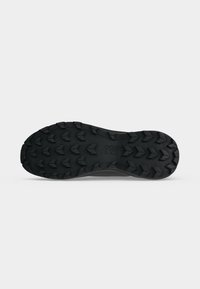 Semelle de chaussure noire et robuste avec des crampons profonds et le logo "PULL&BEAR" embossé au centre sur un fond clair uni.