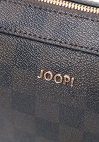 Černá texturovaná peněženka s kostkovaným vzorem, vybavená zlatým logem "JOOP!" a zipem na horním okraji.