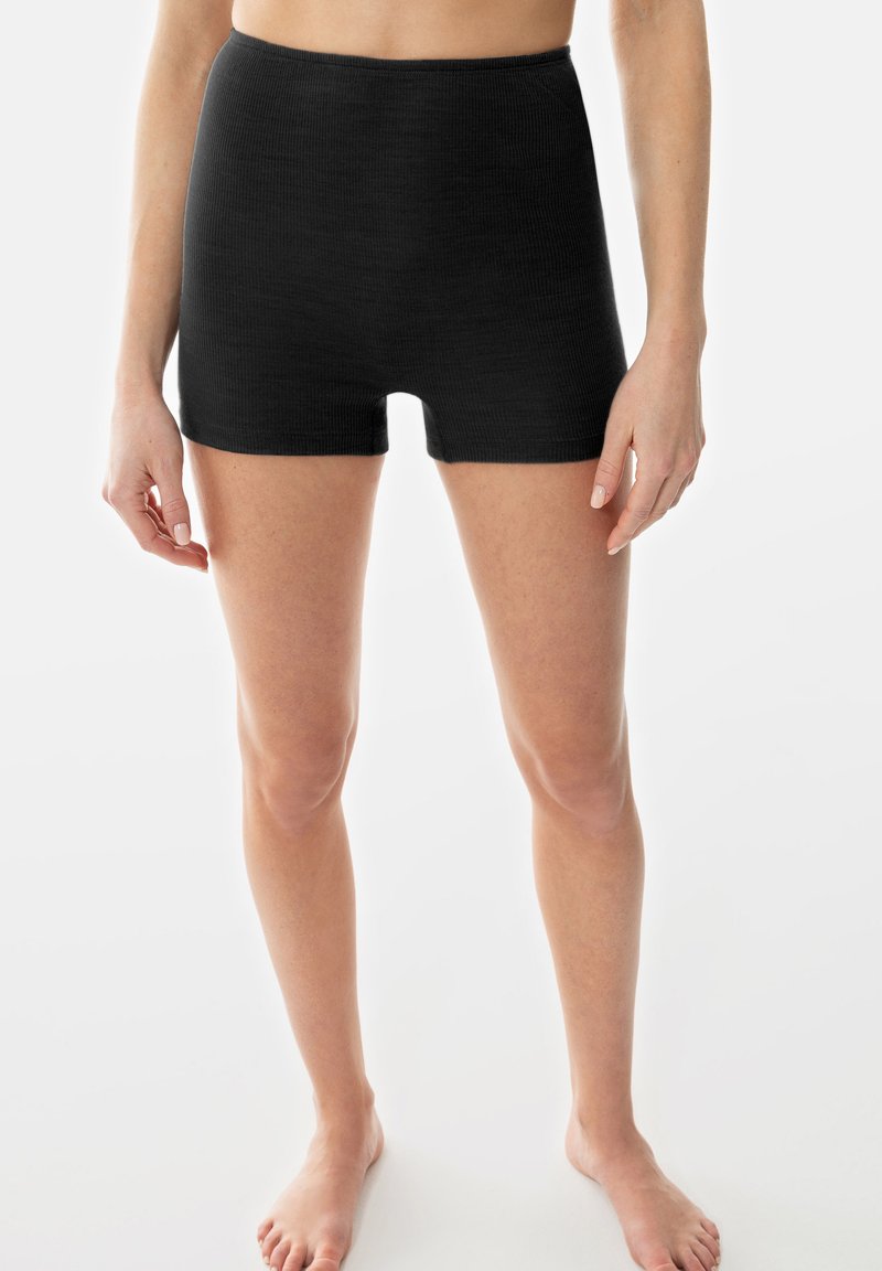 Shorts noirs à côtes avec une taille haute, fabriqués dans un matériau extensible et ajusté, conçus pour atteindre le milieu de la cuisse.
