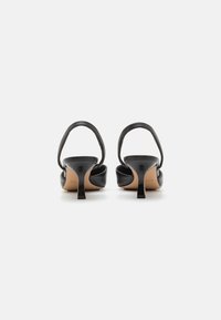 Sandali neri con tacco alto, realizzati in pelle liscia, design con retro aperto e sottile cinturino alla caviglia. Tacco a stiletto e soletta beige visibili.