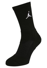 Calza sportiva nera con texture a coste, suola imbottita e logo Jumpman bianco ben visibile sul lato.
