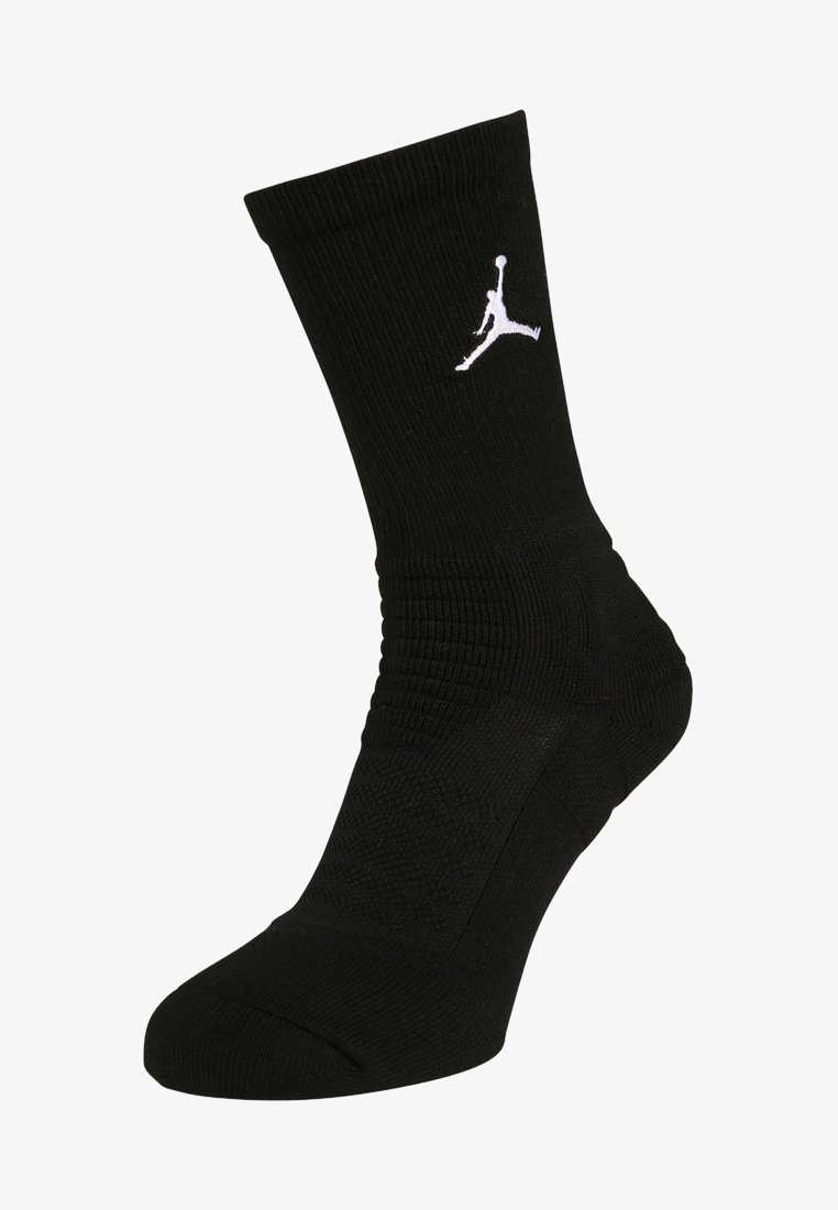 Calcetín deportivo negro con textura acanalada, suela acolchada y un logo Jumpman blanco destacado en el lado.