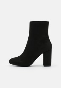Botte de cheville en daim noir avec un bout arrondi et un talon bloc haut. Texture lisse sans aucun matériel ou ornement visible.