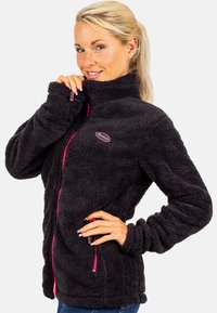 Schwarze Fleecejacke mit hohem Kragen, Frontreißverschluss und pinken Reißverschlussakzenten; zeichnet sich durch eine weiche Textur und geschwungene Nähte aus.