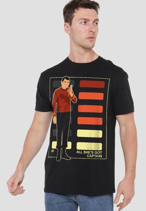Black cotton t-shirt featuring a graphic of a character in a red shirt holding a device, surrounded by colored bars and text.