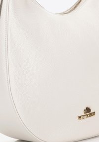 Borsa a mano in pelle bianca texturizzata con forma curvilinea, zip dorata e piccolo logo Wittchen dorato sul lato in basso a destra.