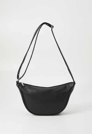 Sac bandoulière en cuir noir avec fermeture éclair argentée et sangle d'épaule réglable sur fond blanc uni.