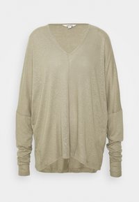 Langärmeliges, olivgrünes V-Ausschnitt-Oberteil mit lockerer Passform, weichem Griff und überschnittenen Schulternähten. Hat einen abgerundeten Saum.