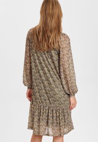 Floral print dress featuring long puff sleeves, a gathered waist, and a tiered ruffle hem. Made from lightweight, sheer fabric.