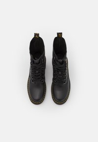 Black leather ankle boots with yellow stitching, round toe, lace-up design, and looped pull tab on the tongue for easy wearing.