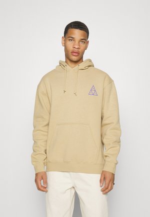 Sudadera con capucha color beige hecha de algodón, con un logo triangular púrpura en el pecho, un bolsillo tipo canguro y puños y dobladillo acanalados.