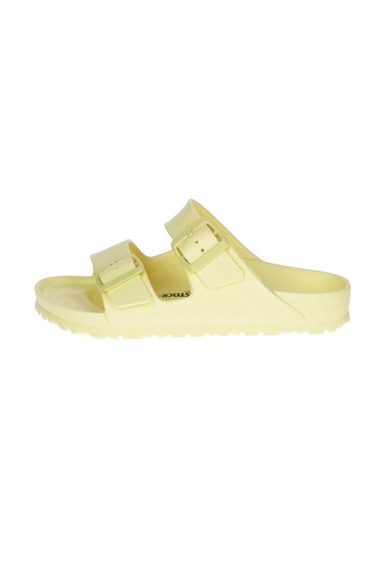 Sandalia amarilla tipo slip-on con dos hebillas ajustables, plantilla texturizada y una suela de goma resistente con un dibujo antideslizante.
