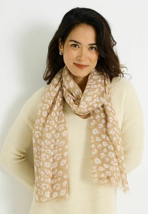 Bufanda beige con un patrón floral en tonos suaves de rosa y blanco. Material ligero con bordes desflecados, colocada alrededor del cuello.