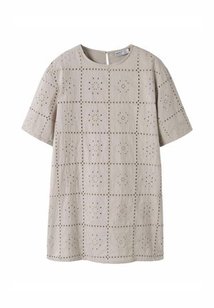 Beige kortermet bluse med rund hals og blomstermønstre med hullutskjæringer arrangert i et rutenettdesign.