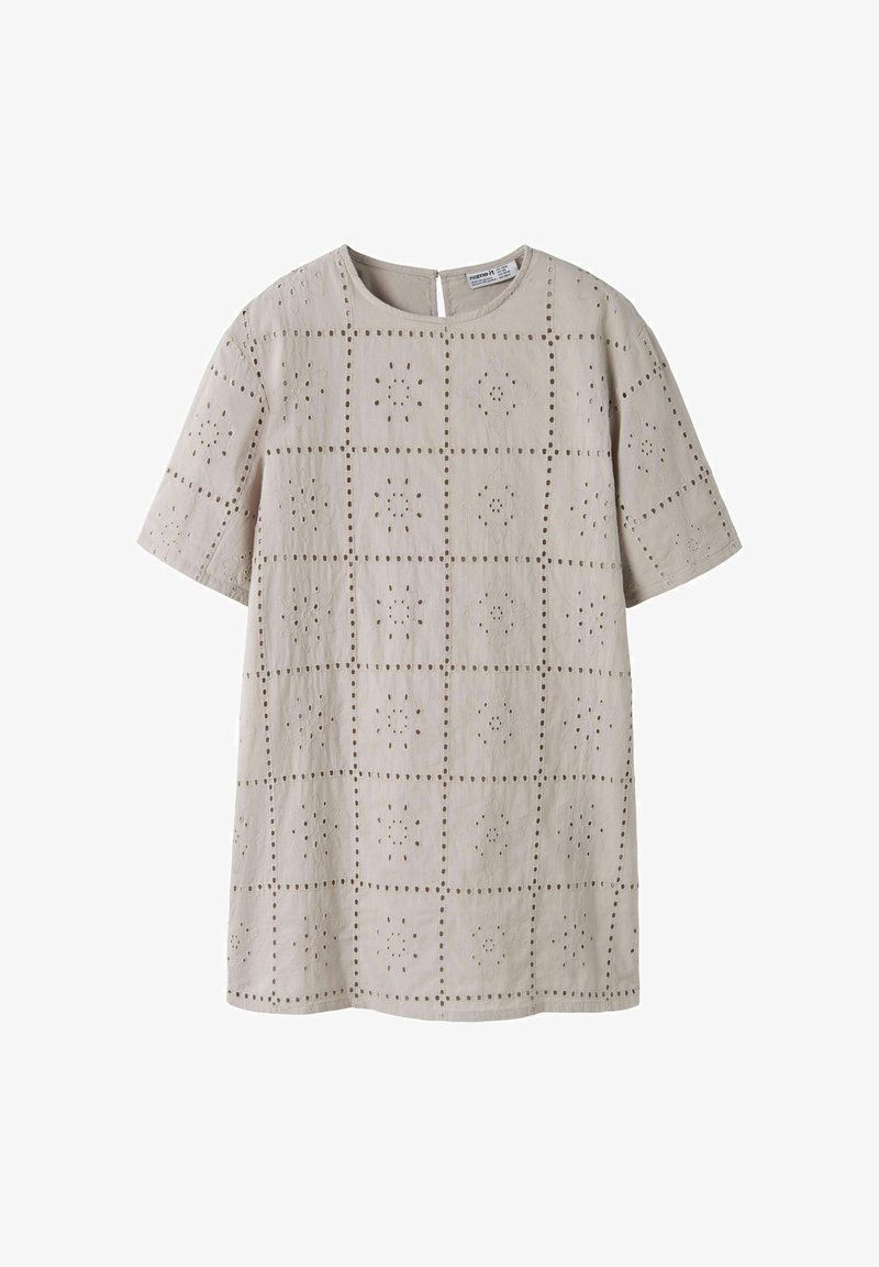 Blouse beige à manches courtes avec encolure ronde et motifs floraux ajourés disposés en motif quadrillé.