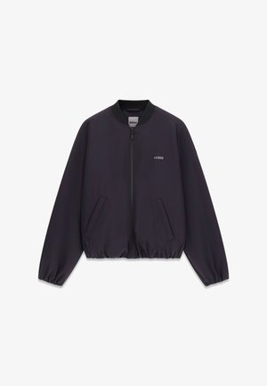 Zwarte bomberjack met een voorrits, zijzakken, geribde kraag en elastische zoom. Heeft een klein wit 'GUESS'-logo op de borst.