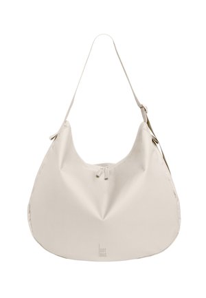 Weiche, beige Schultertasche in Halbmondform mit verstellbarem Riemen und kleinem Reißverschluss vorne, mit der Marke "GOT BAG" unten in der Mitte.