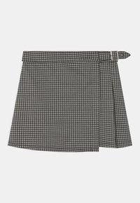 Sort-hvid skakmønstrede nederdel med et bælte, der har et plisseret design og en sidelukning. Fremstillet af struktureret stof.