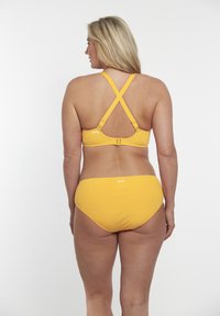 Set di bikini giallo con spalline incrociate regolabili, chiusura a gancio e parte inferiore a vita alta. Tessuto liscio e opaco con minimal branding.
