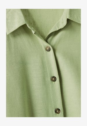 Grüne Button-Up-Hemd aus leichtem Stoff mit strukturierter Oberfläche. Verfügt über einen Kragen und drei braune Knöpfe entlang der Knopfleiste.